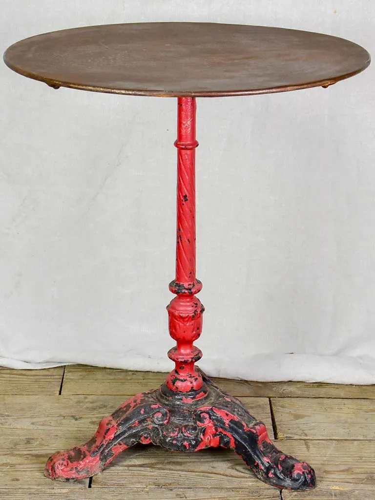 Late nineteenth century French bistro table with red cast iron base